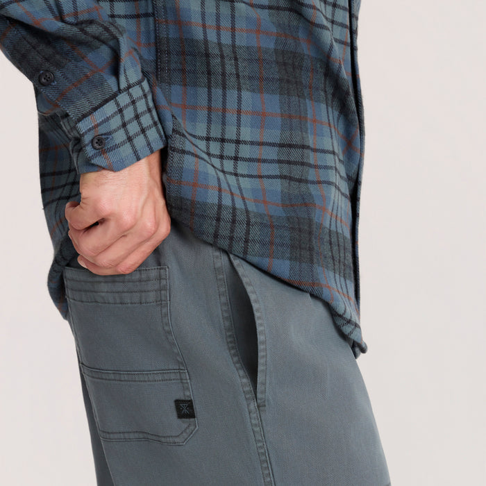 Crossroads organic cotton flannel in dark slate blue with charcoal plaid pattern, worn with hand in pocket on model showing cuff detail
