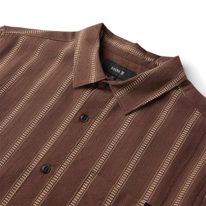 Brown button-up shirt with white vertical striped pattern, featuring black buttons and collar detail, flat lay view