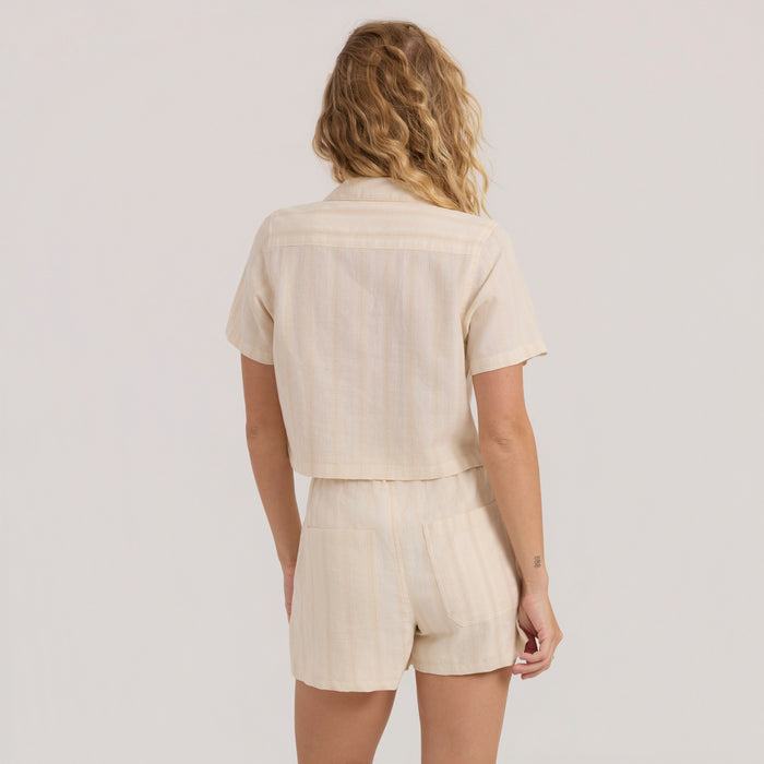 Close-up of a stylish linen sweater detailing with buttons, collar, and pocket, perfect for adventure and travel, by Roark.