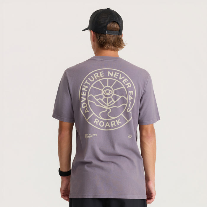 Gray short-sleeve t-shirt with circular back graphic reading "Adventure Never Fails Roark" in tan, worn by model with black cap