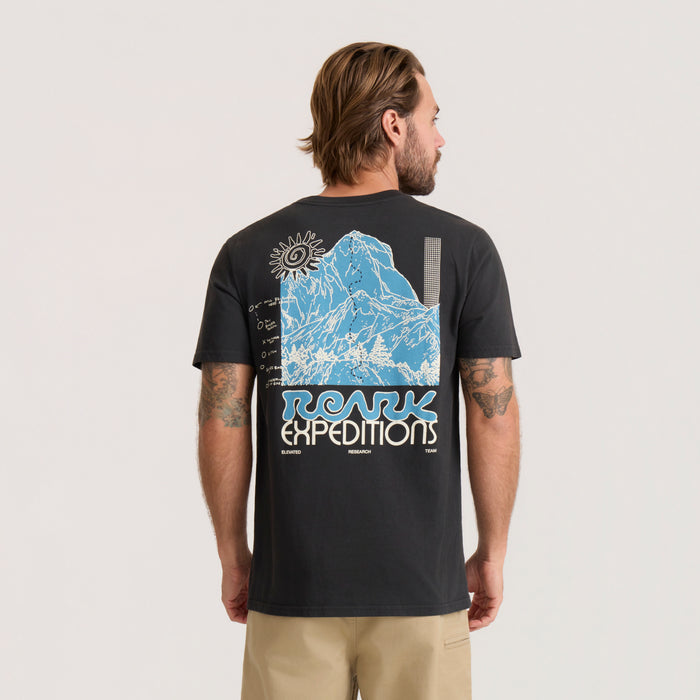 Black short-sleeve tee with blue mountain illustration and Roark Expeditions graphic print on back, worn by man in profile view