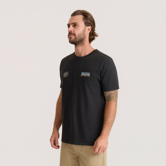 Black Elevated Research Premium Tee with sun and logo embroidery on chest, worn by man with beige shorts against neutral background