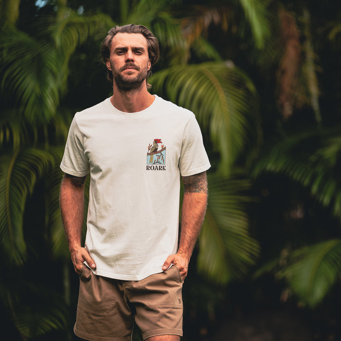 Man with a beard wearing Roark's active tee and boardshorts, embodying a spirit of adventure and outdoor lifestyle.