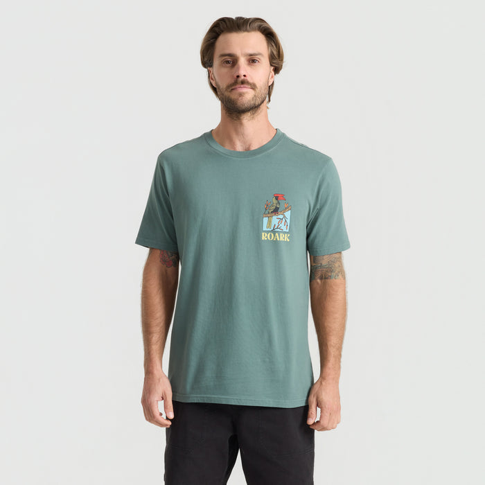 Close-up of a durable active shirt by Roark, featuring sleeves, textured fabric and a secure pocket, ideal for adventure and travel.