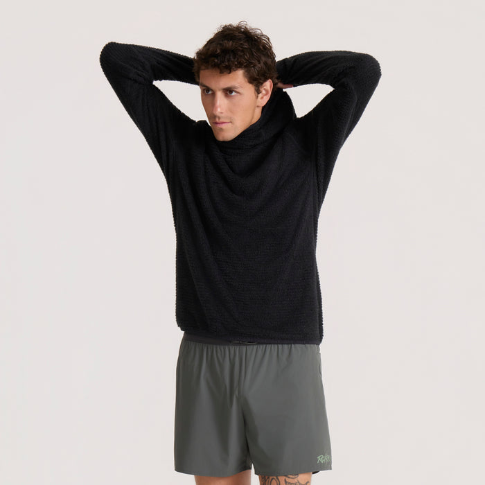 Black Evolve hoodie on male model with hands behind head, paired with gray shorts