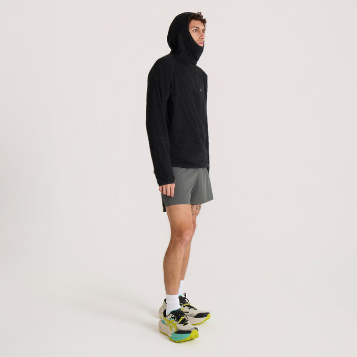 Black Evolve hoodie with hood worn by male model with gray shorts and colorful sneakers, side view