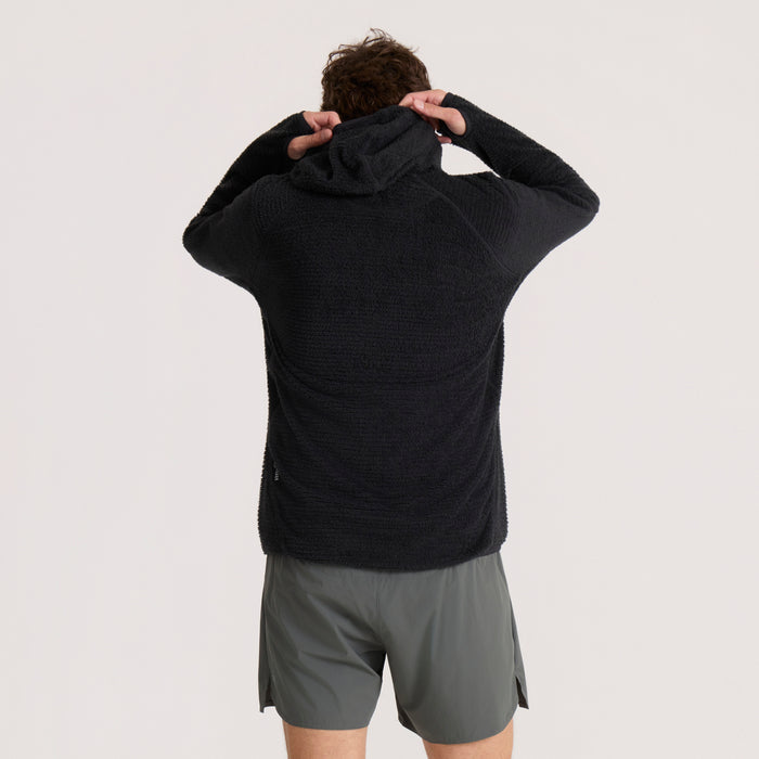 Black Evolve hoodie worn by model from behind, showing textured knit fabric and drawstring hood detail