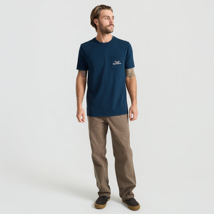 Active man standing wearing Roark's navy adventure shirt featuring functional pockets and designed for travel.