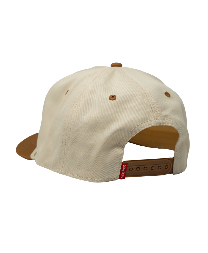 Beige cap with brown brim and red tag on a white background