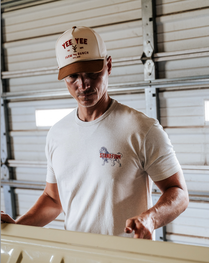 Man wearing a cap and t-shirt with logos in an indoor setting