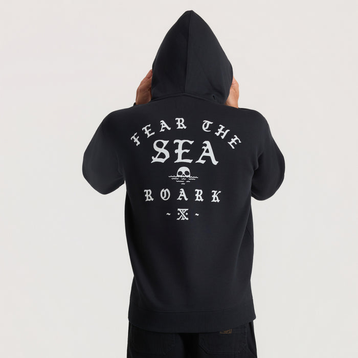 Black Roark hoodie with "Hear The Sea Roark" text and skull graphic printed on back, shown from behind on model