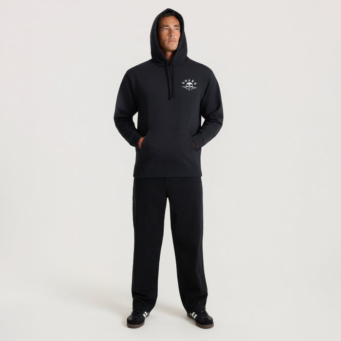 Black Fear The Sea hoodie with small logo on chest, worn by model with hands in pockets in full-length view