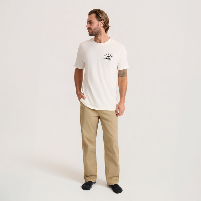 Fear The Sea Premium Tee in off white with small chest graphic, worn by man with tan pants on neutral background