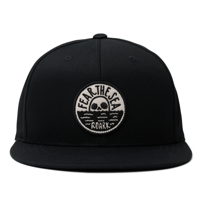 Artistic graphic featuring a skull with a moustache and a cricket cap on a black background, embodying Roark’s adventurous spirit.