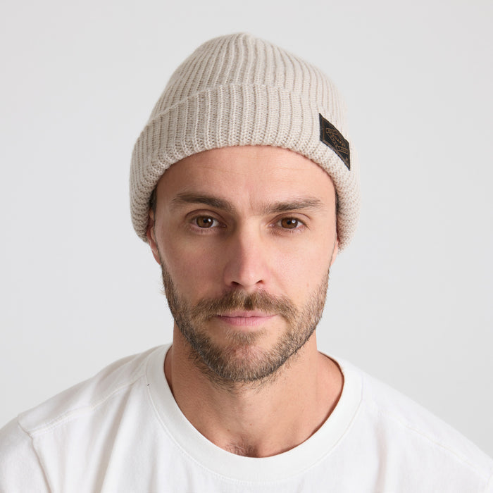 Man with a thick beard wearing a knit beanie, embodying Roark's adventurous and outdoor spirit.