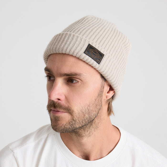 Man with facial hair wearing a cozy wool knit beanie in a natural outdoor setting, embodying Roark's adventure and travel spirit.