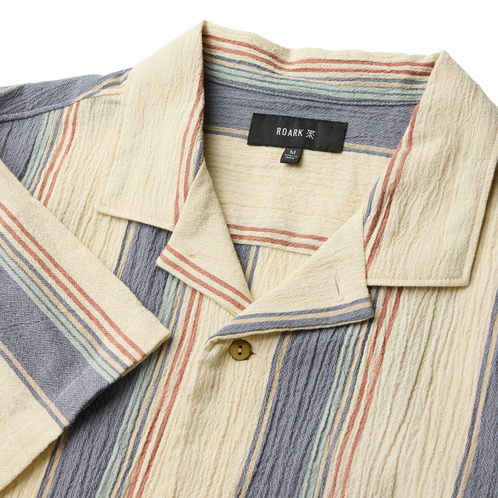 Close-up of a durable button on a Roark outdoor garment, designed for adventure and travel.