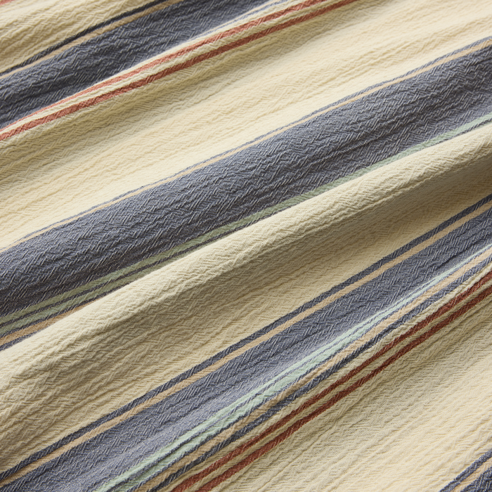 Close-up of a woven fabric in shades of brown and grey, crafted from wool, reflecting Roark's commitment to high-quality, adventure-ready textiles.