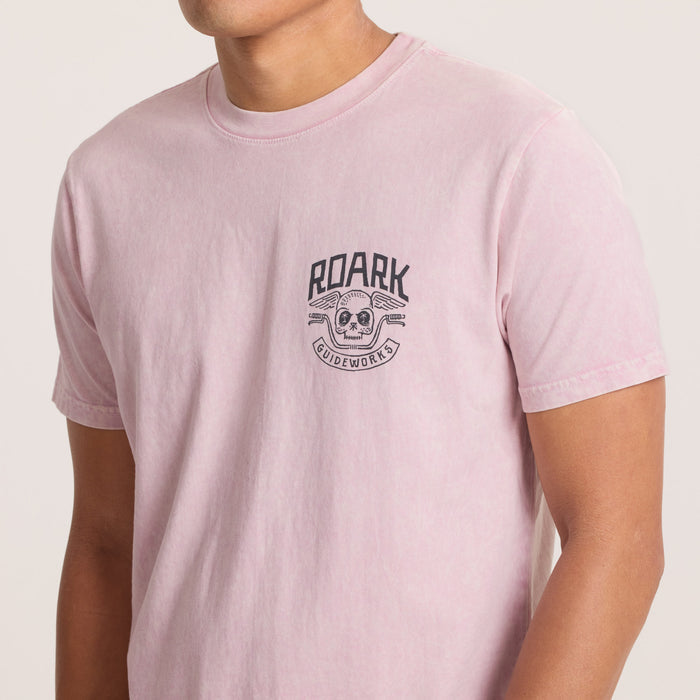 Detailed view of front logo on pink Roark Guideworks T-shirt.