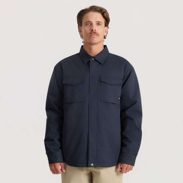 Man wearing deep navy Hebrides 10k jacket with dual chest pockets and button front closure on neutral background