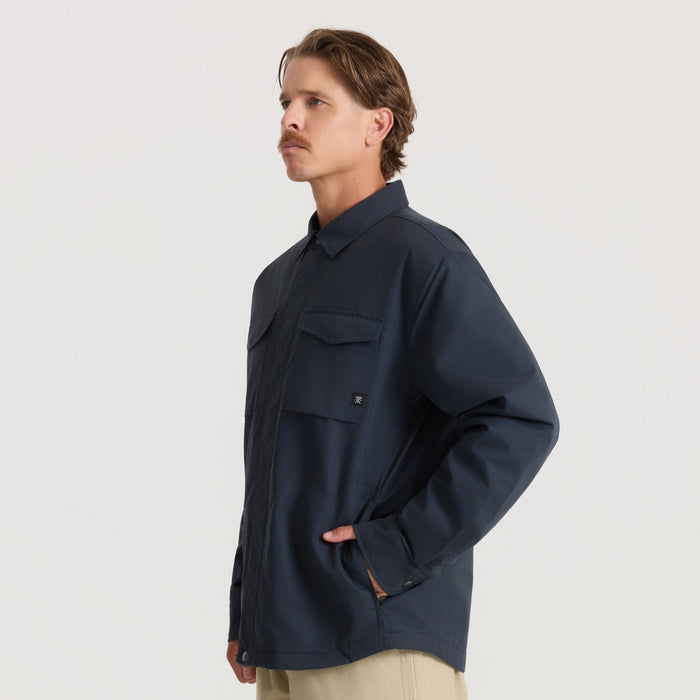 Hebrides 10k Jacket in deep navy with chest pockets, worn by man standing in profile against neutral background