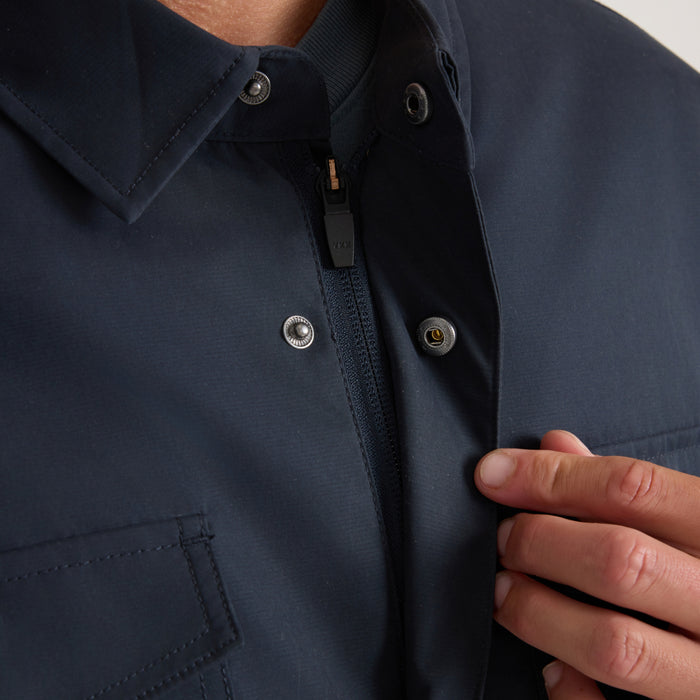 Navy Hebrides 10k jacket on model showing snap button closure, ribbed collar, and black fleece interior detail