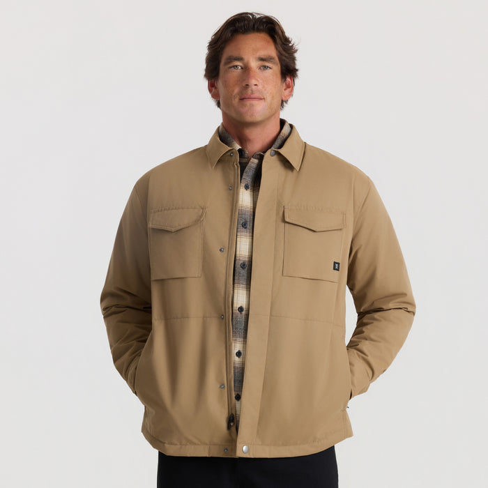 Khaki Hebrides 10k Jacket with button front, chest pockets, and plaid shirt visible underneath on male model