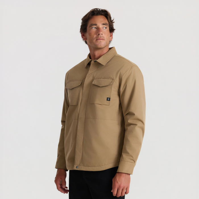 Tan Hebrides 10k jacket with front chest pockets worn by man against neutral background