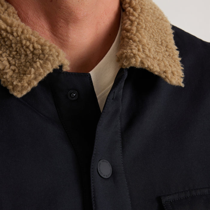 Black Hebrides 2.0 Sherpa Jacket with tan fleece collar worn on model, showing button detail and cream undershirt