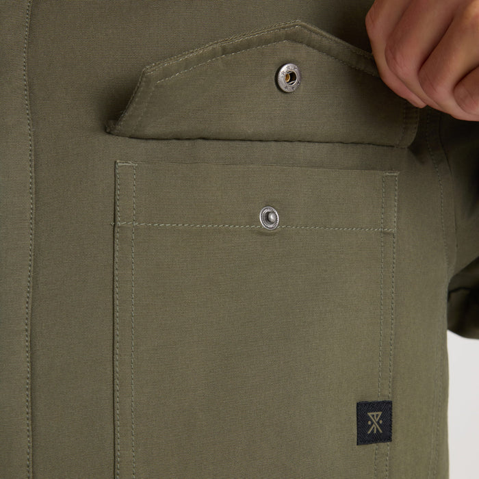 Khaki green sherpa jacket chest pocket with silver snap buttons and brand label detail, worn on model