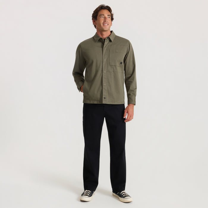 Hebrides 2.0 unlined jacket in military green worn by man with black pants and canvas sneakers, full-length front view
