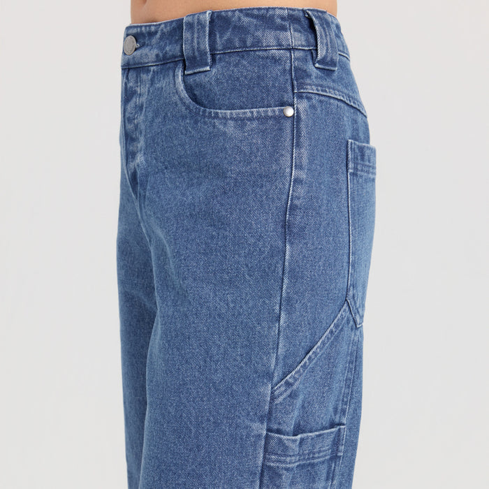 Close-up of a denim pocket featuring a sturdy button, highlighting the durable fashion and textile design ideal for travel and outdoor adventures.
