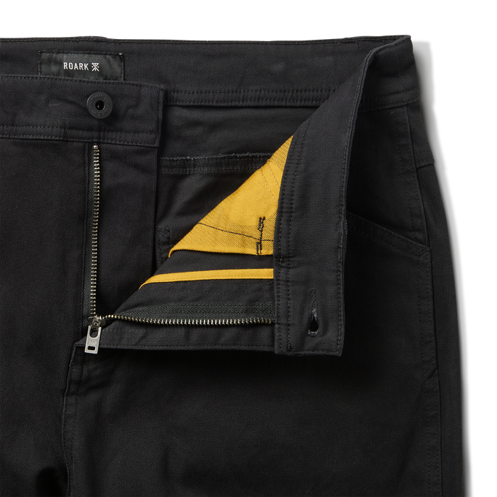 Close-up of black denim fabric featuring detailed pocket stitching, perfect for adventurous travels and outdoor lifestyles.
