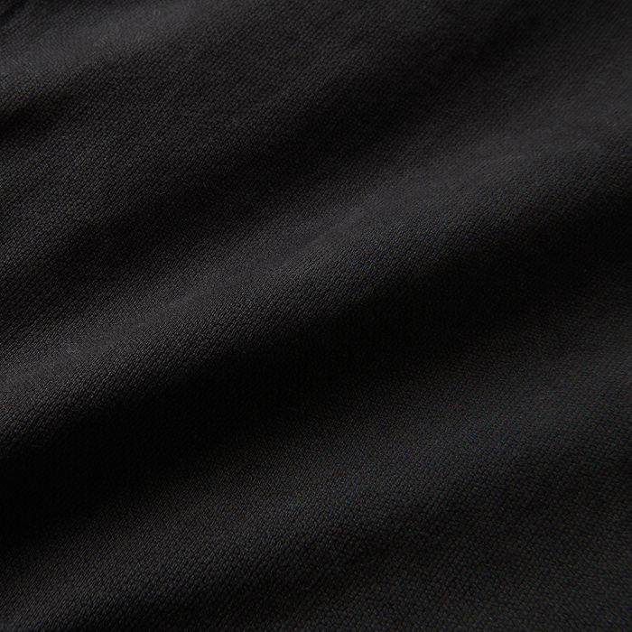 Close-up of a textured black textile material, highlighting the intricate fabric details suitable for outdoor adventure gear by Roark.