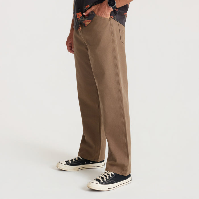 HWY 1 Utility Denim in mushroom tan worn by model with black canvas sneakers, side view showing relaxed fit and straight leg silhouette