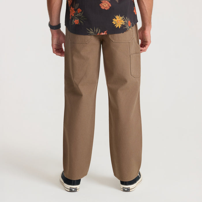 Tan HWY 1 utility denim with cargo pockets shown from behind on male model wearing floral shirt
