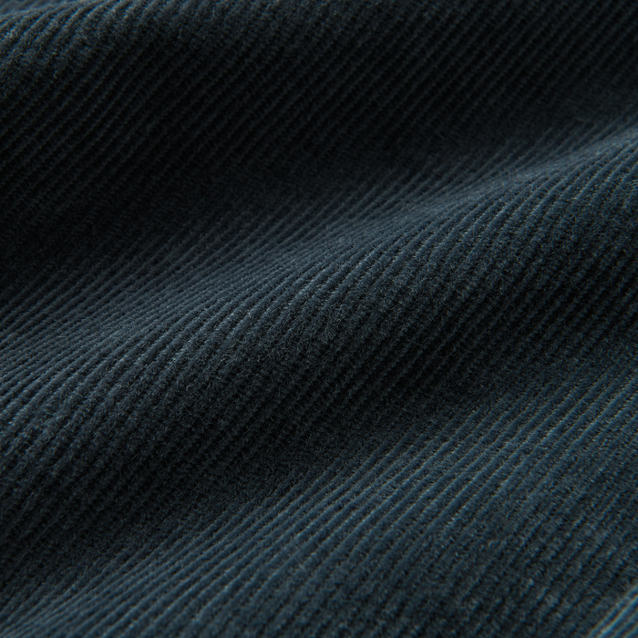 Close-up detail of mixed fabrics featuring denim and wool, highlighting the texture and quality suitable for adventure and travel apparel by Roark.