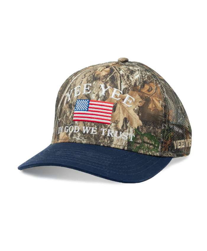 Camouflage cap with American flag and 'In God We Trust' text on a white background