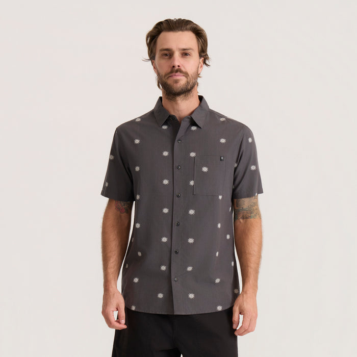 Charcoal Journey short sleeve button up shirt with white daisy print, worn by male model against neutral background