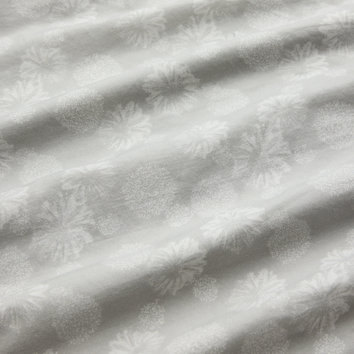 Grey textile with intricate creative motif laying flat, showcasing Roark's flair for blending artistic elements with outdoor gear aesthetics.