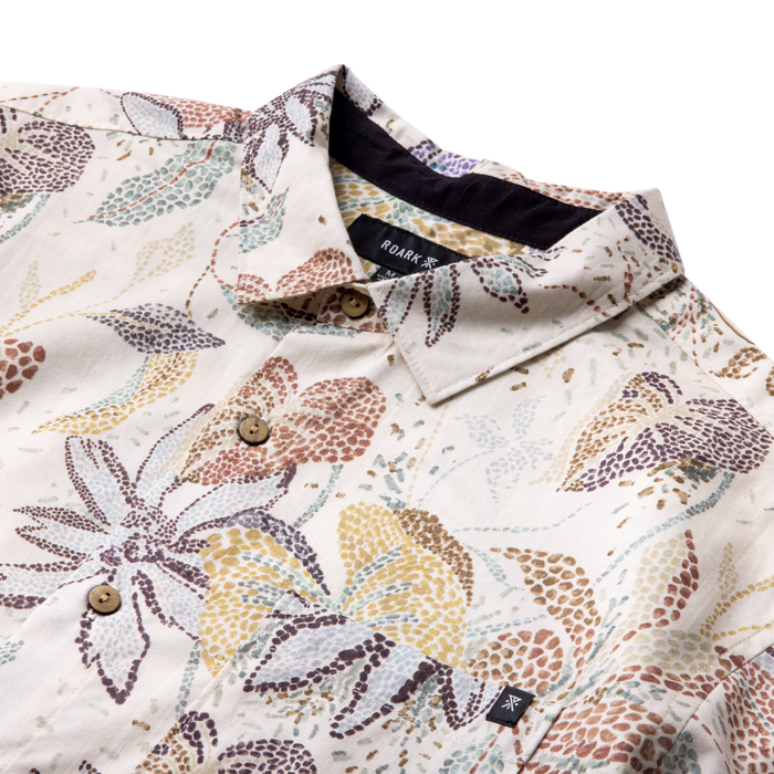 Ivory short sleeve button-up shirt with multicolored leaf and dotted pattern, featuring wooden buttons and collar detail