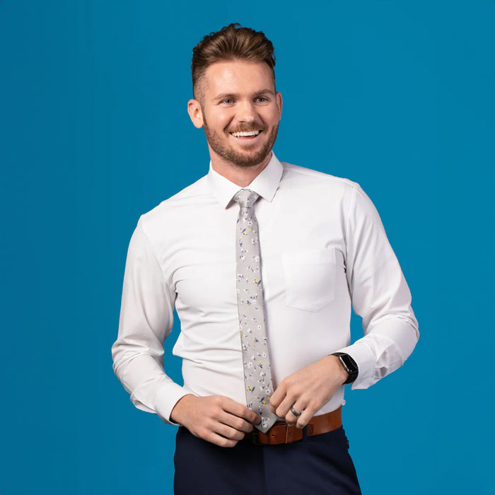 Grey tie with blue, yellow, and white floral patterned design on white dress shirt