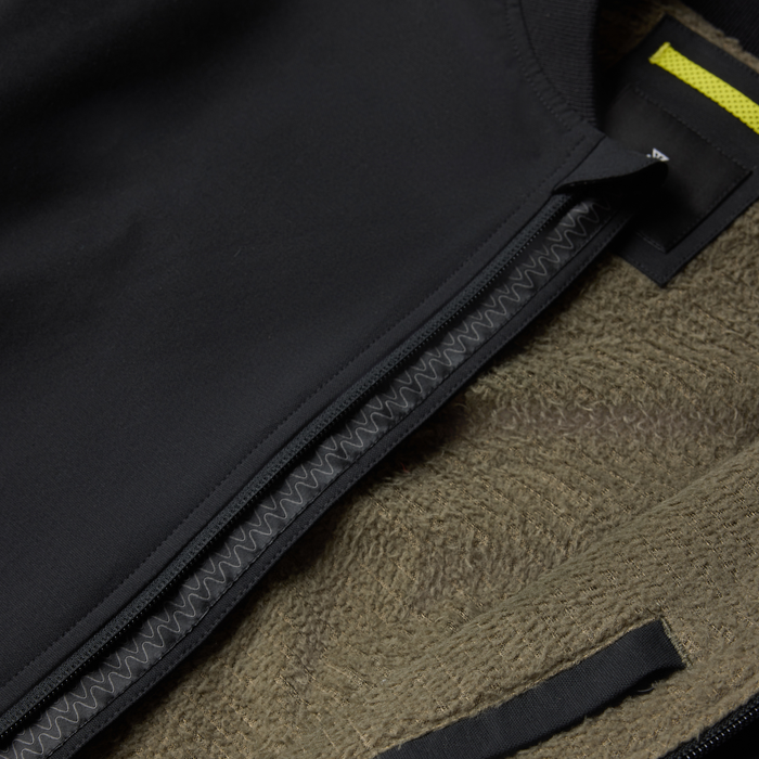 Layover Bomber Jacket in black with visible zipper detail and yellow stripe trim on flat lay surface