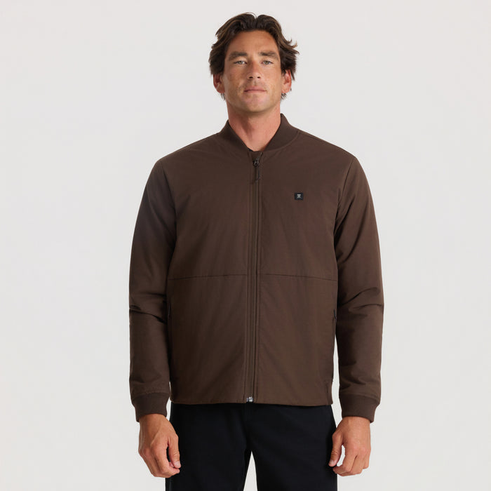 Layover Bomber Jacket in tobacco brown worn by man on neutral background, front view showing full zip closure and small logo patch