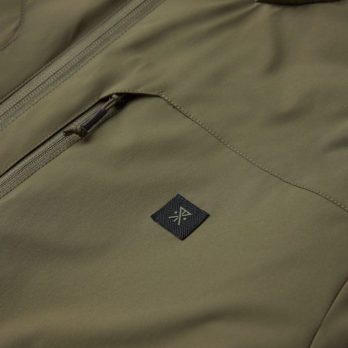 Khaki Layover Jacket in military color with visible zippered pocket and branded patch detail on fabric