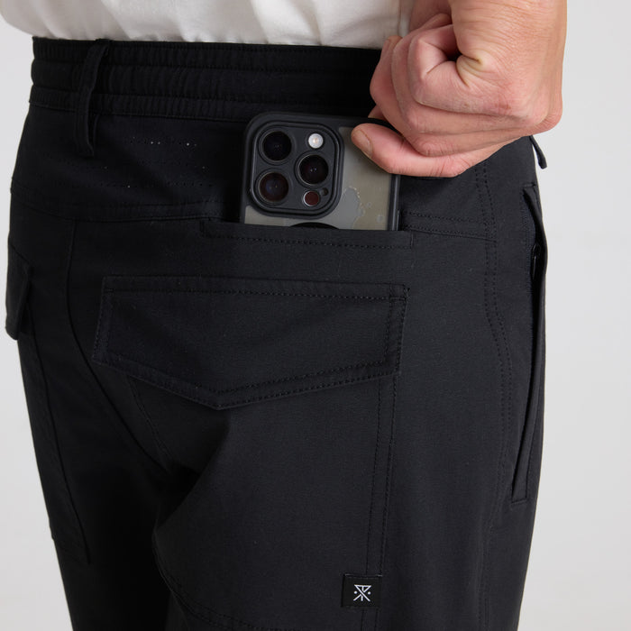 Versatile black cargo pants designed for adventure and outdoor activities by Roark, featuring multiple pockets and durable fabric for all your travel needs.