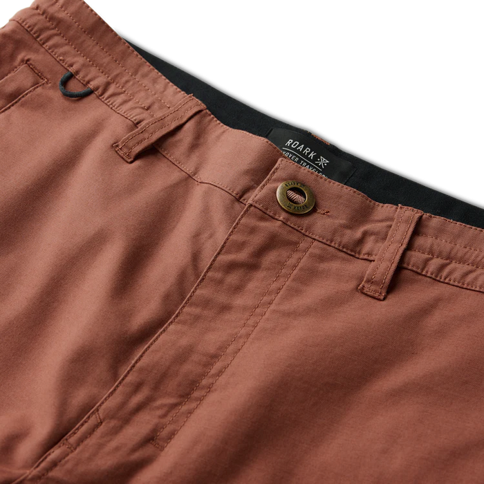 Roark Layover Pro Traveler Shorts in red clay, flat lay detail shot showing waistband, button, and pocket construction