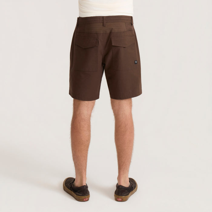 Brown Layover Pro 8" Traveler Shorts worn by model from back view, showing rear patch pockets and relaxed fit