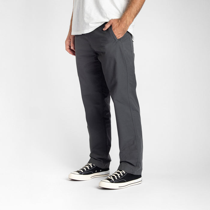 A person wearing Roark's Layover Pro Charcoal pants and walking shoes, demonstrating their versatility and comfort on-the-go, ideal for travel and outdoor activities.