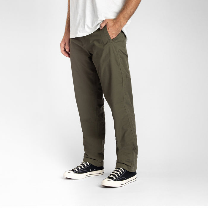 Man walking in versatile Layover Pro Military cargo pants, perfect for travel and outdoor adventures